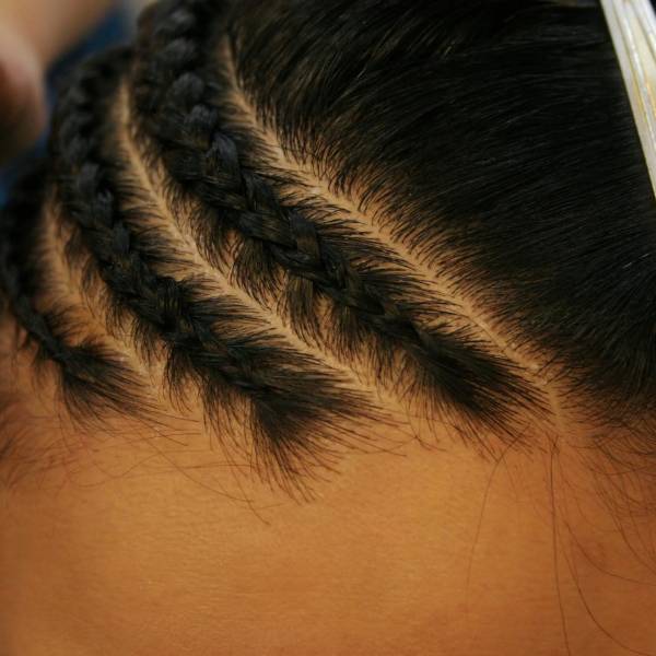 Close-up of braided hair with a comb on a person's head